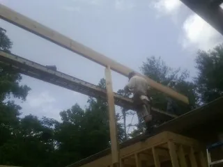 Carpenter setting a ridge beam over a new addition frame — Ice Dam Removal by Roofing Brothers in Edwards